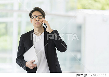スマートフォンをで通話する眼鏡をかけた30代の男性 カジュアルビジネス イメージ スマートフォンをで通話する眼鏡をかけた30代の男性 カジュアルビジネス イメージ 78125633