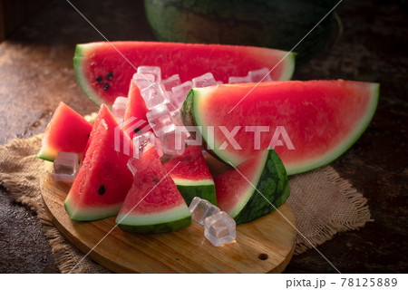 watermelon and watermelon pieces in a wooden background 78125889