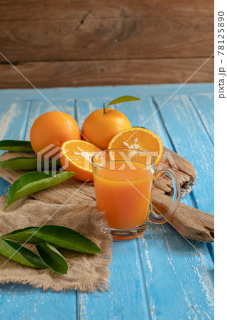 Fresh orange and a glass of orange juice on a wooden table background 78125890