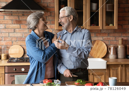 Joyful mature couple of vegans cooking dinner together at home Joyful mature couple of vegans cooking dinner together at home 78126049