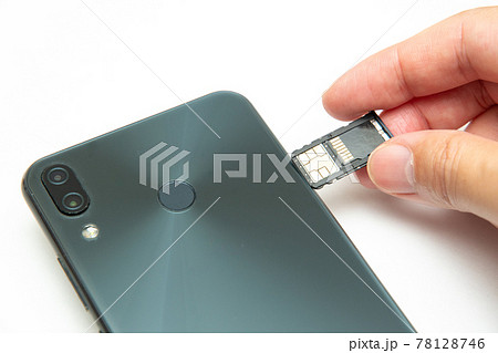 スマートフォンにシムカードを差し込むシーン  白背景 78128746