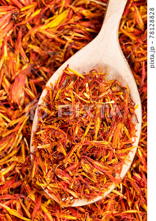spoon with dried safflower petals close up on pile spoon with dried safflower petals close up on pile 78128828