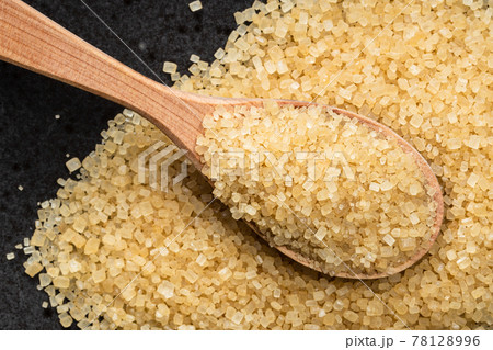 spoon with demerara brown cane sugar on black 78128996