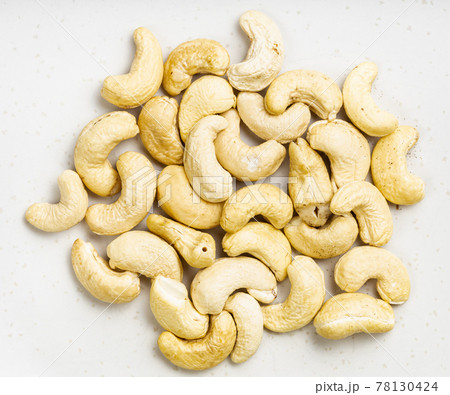 pile of raw cashew seeds close up on gray pile of raw cashew seeds close up on gray 78130424