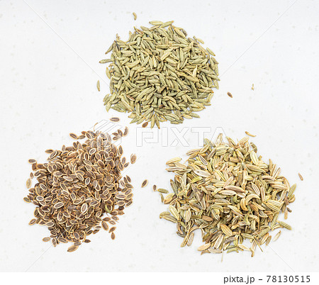 piles of anise, dill and fennel seeds on gray piles of anise, dill and fennel seeds on gray 78130515