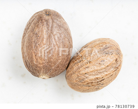 top view of two whole nutmeg fruits on gray top view of two whole nutmeg fruits on gray 78130739
