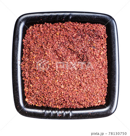 ground sumac spice in black bowl isolated 78130750