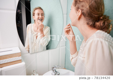 Cheerful young woman brushing teeth with braces. Cheerful young woman brushing teeth with braces. 78134420