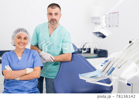 Handsome dentist with young female assistant in uniform 78136142