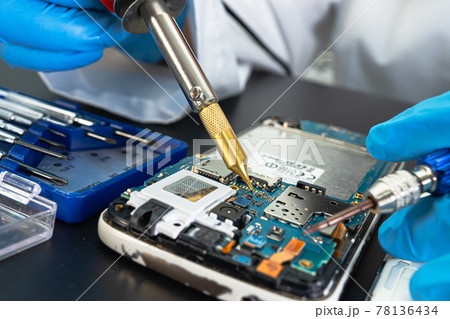 Technician repairing inside of mobile phone by soldering iron. Integrated Circuit. the concept of data, hardware, technology. 78136434