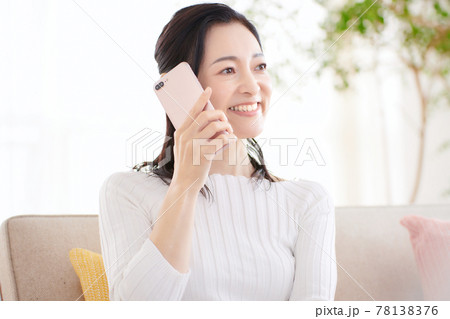 リビングでスマホを見るミドル女性 リビングでスマホを見るミドル女性 78138376