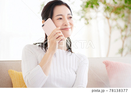 リビングでスマホを見るミドル女性 リビングでスマホを見るミドル女性 78138377
