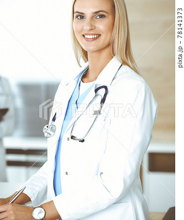 Doctor woman controls medication history records and exam results while using clipboard. Medicine and healthcare concept Doctor woman controls medication history records and exam results while using clipboard. Medicine and healthcare concept 78141373