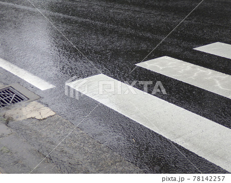 雨に濡れた横断歩道のあるアスファルトの道路 78142257