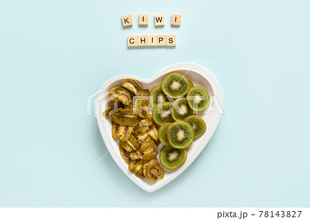 Dried and fresh kiwi chips on blue. 78143827