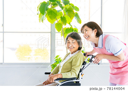 車いすを押す介護スタッフとシニア女性 車いすを押す介護スタッフとシニア女性 78144004