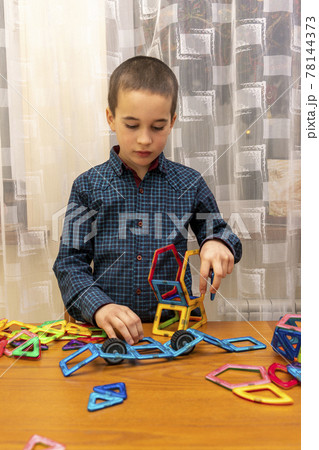 boy playing with magnetic constructor toy. Cute little boy playing with colorful magnetic constructor toy. toned 78144373