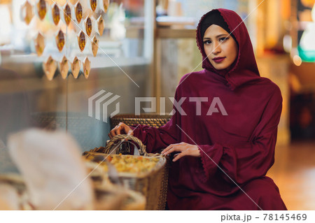 Arabian young muslim woman sitting in a cafe. Arabian young muslim woman sitting in a cafe. 78145469