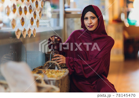 Arabian young muslim woman sitting in a cafe. Arabian young muslim woman sitting in a cafe. 78145470