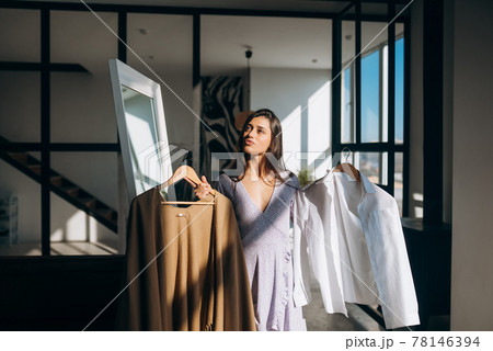 Beautiful girl trying dress in room 78146394