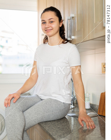Portrait of young woman posing in kitchen 78147312