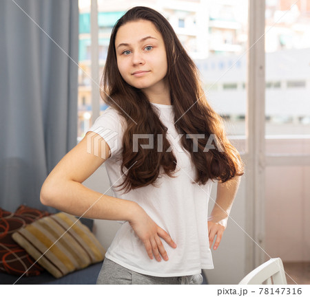 Young cheerful woman posing in living room 78147316