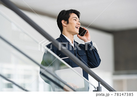 スマホで話す作業服の男性 78147385