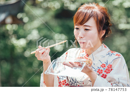 夏祭りでたこ焼きを食べる浴衣姿の女性 夏祭りでたこ焼きを食べる浴衣姿の女性 78147753