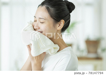 タオルで顔を拭く若い女性 78147794