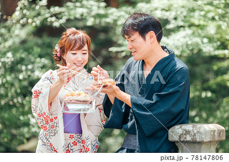夏祭りにきて焼きそばやたこ焼きを食べる男女 夏祭りにきて焼きそばやたこ焼きを食べる男女 78147806