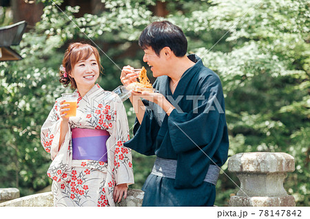 夏祭りにきてビールや焼きそばを食べる男女 夏祭りにきてビールや焼きそばを食べる男女 78147842