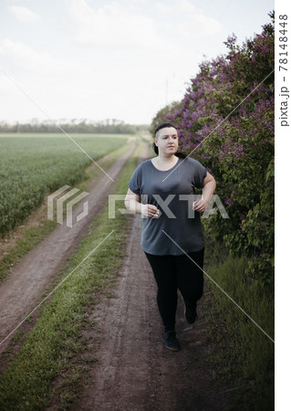Overweight woman jogging outdoors at the open air Overweight woman jogging outdoors at the open air 78148448