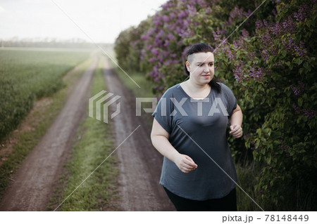 Overweight woman jogging outdoors at the open air 78148449