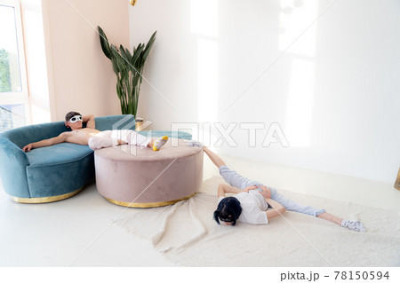 Couple in pajamas resting at home by creative way. Concept of boredom during COVID self isolation Couple in pajamas resting at home by creative way. Concept of boredom during COVID self isolation 78150594
