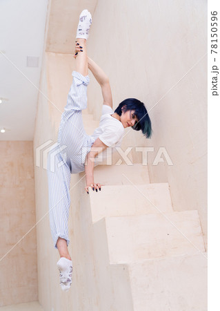 Flexible girl doing stretching and handstand in studio. Concept of individuality, creativity and self-confidence Flexible girl doing stretching and handstand in studio. Concept of individuality, creativity and self-confidence 78150596