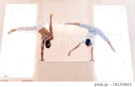 Couple Yoga, man and woman doing high level yoga exercises and handstand indoor. Healthy lifestyle concept Couple Yoga, man and woman doing high level yoga exercises and handstand indoor. Healthy lifestyle concept 78150603