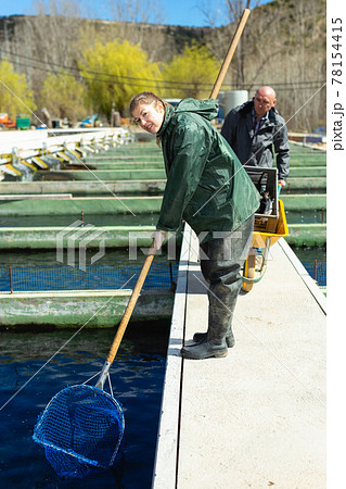 Male farmer with woman catching trout 78154415
