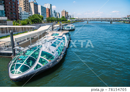 日本の東京都市景観　隅田川と水上バス「エメラルダス」、「ホタルナ」。奥に特急 78154705