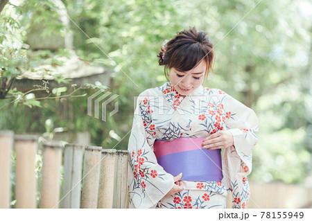 帯を直す浴衣姿の女性の写真素材
