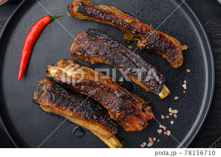 Pork ribs grilled with BBQ sauce and caramelized in honey, on plate, on black wooden table background, top view flat lay 78156710