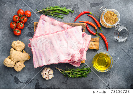 Raw ribs with a rosemary and vegetables, on gray background, top view flat lay Raw ribs with a rosemary and vegetables, on gray background, top view flat lay 78156728