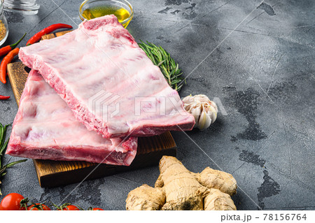 Raw pork meat ribs with ingredients for cooking, on gray background, with copy space for text Raw pork meat ribs with ingredients for cooking, on gray background, with copy space for text 78156764
