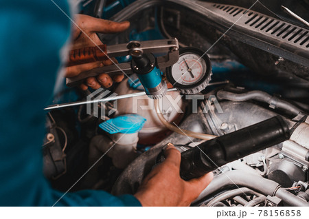 Professional car mechanic working in a car service, computer diagnostics of the bonnet space in the car. Professional car mechanic working in a car service, computer diagnostics of the bonnet space in the car. 78156858