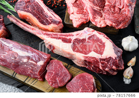 Tomahawk raw fresh beef steak with spices, with seasoning and herbs, on black wooden table background, top view flat lay 78157666