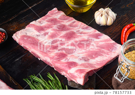 Fresh raw pork ribs with rosemary and garlic, on old dark wooden table Fresh raw pork ribs with rosemary and garlic, on old dark wooden table 78157733