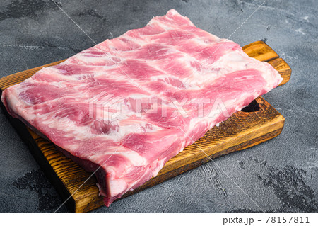 Fresh raw pork ribs , on wooden cutting board, on gray stone background Fresh raw pork ribs , on wooden cutting board, on gray stone background 78157811