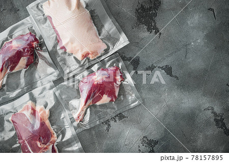 Duck meat vacuum packed, on gray stone background, top view flat lay, with copyspace and space for text 78157895