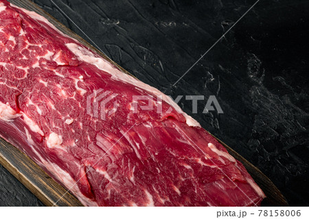 Fresh and raw beef meat. Whole piece of tenderloin with steaks, on black stone background, with copy space for text 78158006