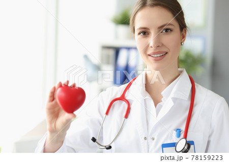 Portrait of female doctor cardiologist with small heart in her hand Portrait of female doctor cardiologist with small heart in her hand 78159223