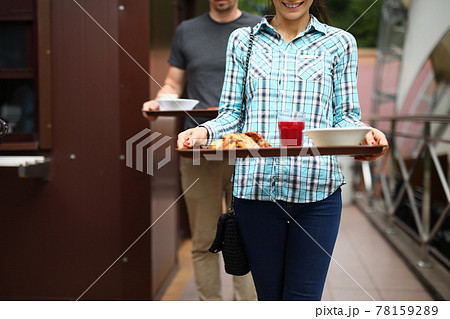 Woman and man are carrying food trays Woman and man are carrying food trays 78159289